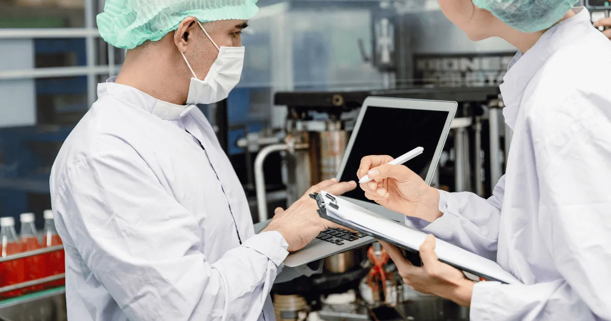 Summit-Health_Industrial-Hygiene-Consulting Consultant and employee in an industrial hygiene setting talking with laptops and clipboards